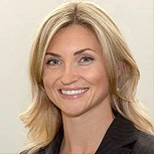 Smiling male dentist in black scrubs standing outdoors